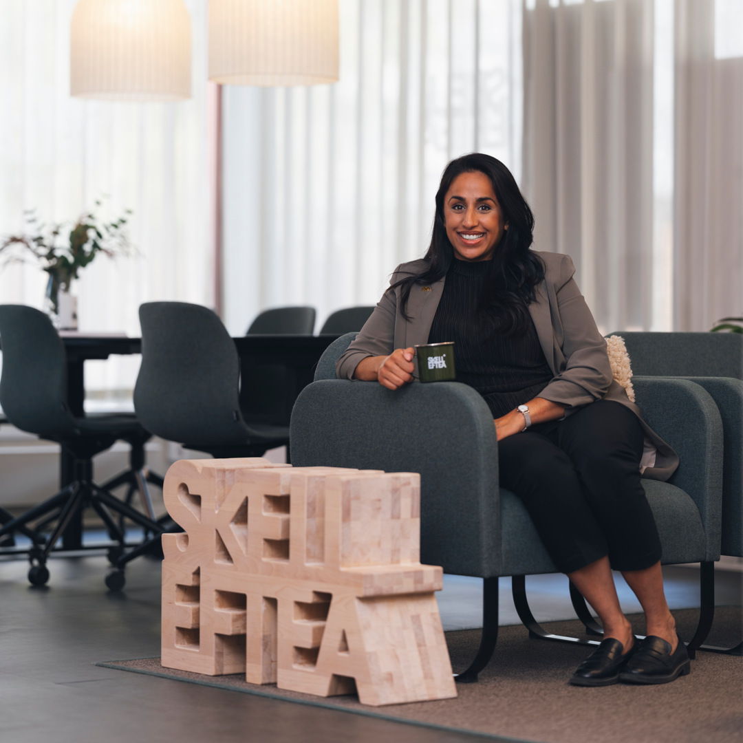 A woman sitting on a couch in an office.