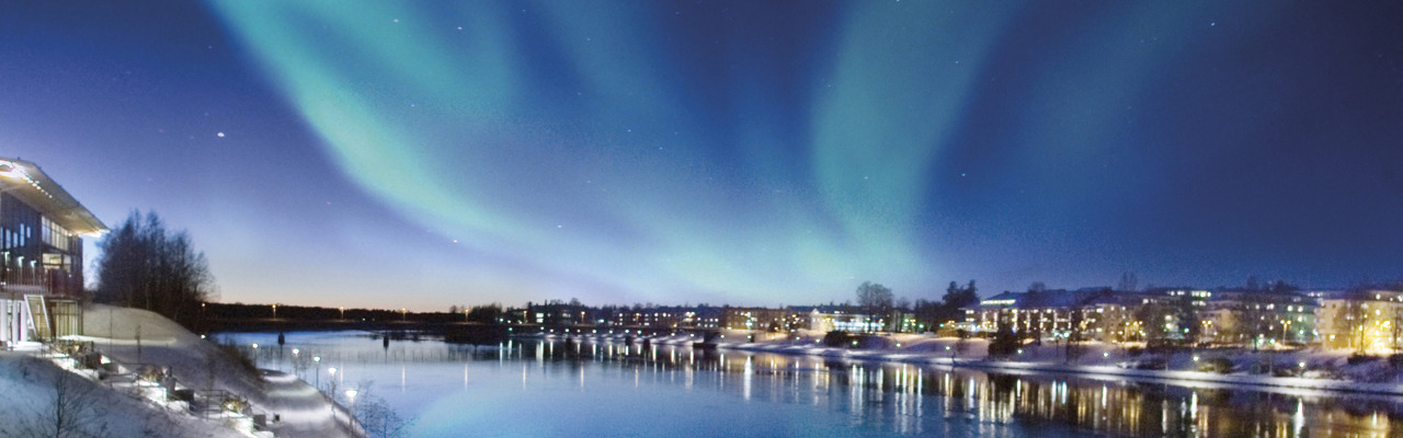Norrskenet reflekteras i vattnet. Över Skellefteå älv.