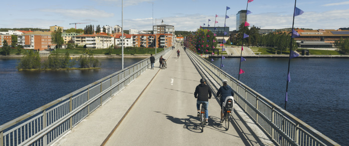 En grupp människor som cyklar över en bro.