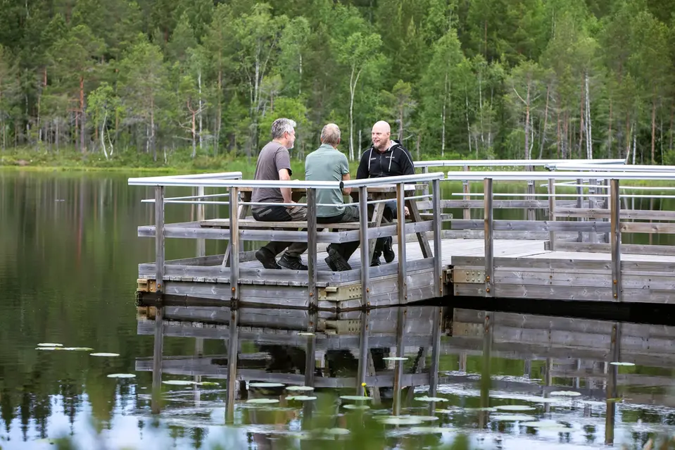 Bild från arbetsdagen där Johannes sitter på en brygga tillsammans med två andra män. Fotograf Patrick Degerman