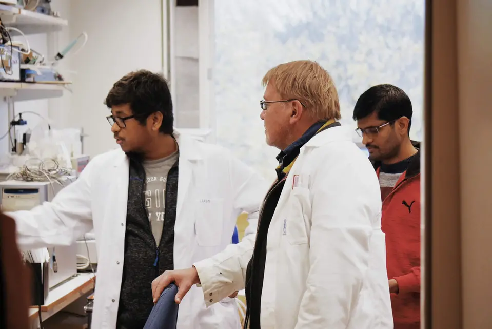 män i laboratoriemiljö med vita rockar