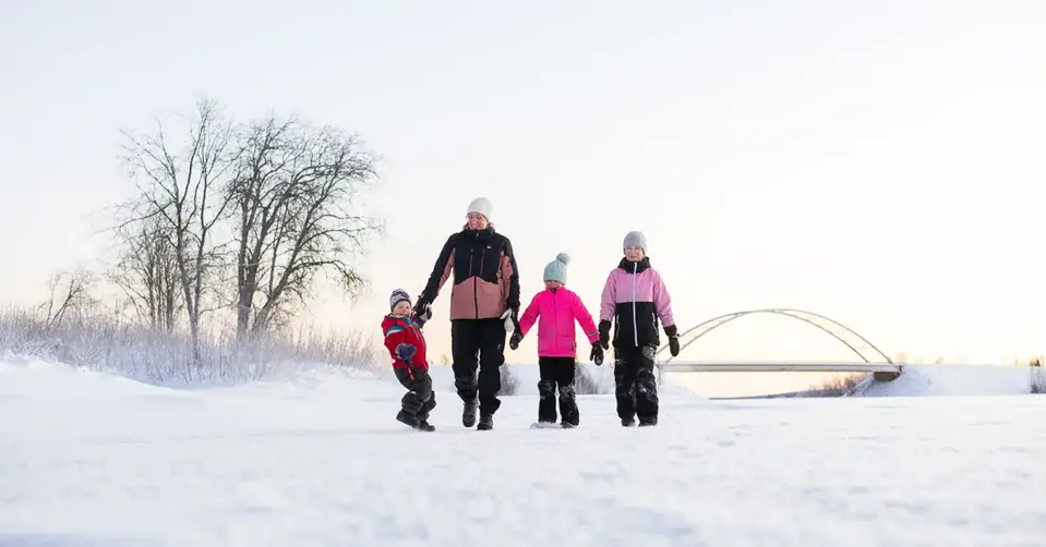 Sofia är ute på promenad med sina tre barn. De håller varandra i handen medan de går. Det är vinter och mycket snö.