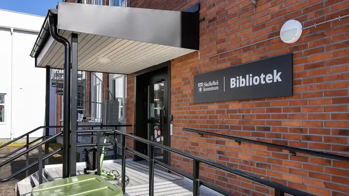 En tegelbyggnad med en skylt där det står bibliotek.